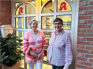 Zwei Frauen lachen in die Kamera.
