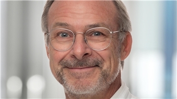 Mann mit Brille und Bart in einem weißen Kittel. Jörg Retzlaff, Chefarzt der Unfallchirurgie und Orthopädie der Helios-Klinik in Nordenham.