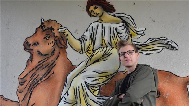 Joshua Henning steht in Hepstedt im sogenannten Europa-Tunnel. Graffiti-Künstler haben ihn im Auftrag der Gemeinde mit Motiven dekoriert, die die Verbundenheit des Dorfes mit anderen ländlichen Kommunen in der EU betonen. Hier ist eine Abbildung der Figur Europa aus der griechischen Mythologie zu sehen.