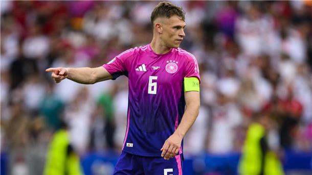 Joshua Kimmich zeigt auf dem Fußballplatz die Richtung an. 