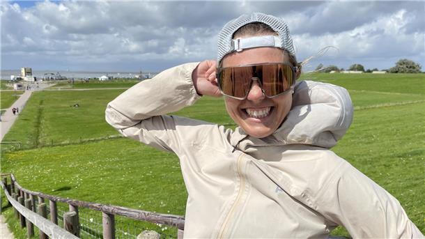 Joyce Hübner auf dem Tossenser Deich. Der Wind weht so stark, dass sie ihre Mütze festhalten muss.