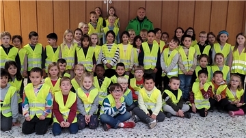 Jürgen Zimmer von der Verkehrswacht Nordenham freut sich mit den Erstklässlerinnen und Erstklässlern der Südschule über die Warnwesten.