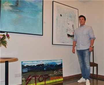 Justin Hofschildt vor den Werken „Into the Blue“ (links) und „Homeport“. Das untere Bild gegen die Weservertiefung hat er am Vorabend der Vernissage erst fertiggestellt.
