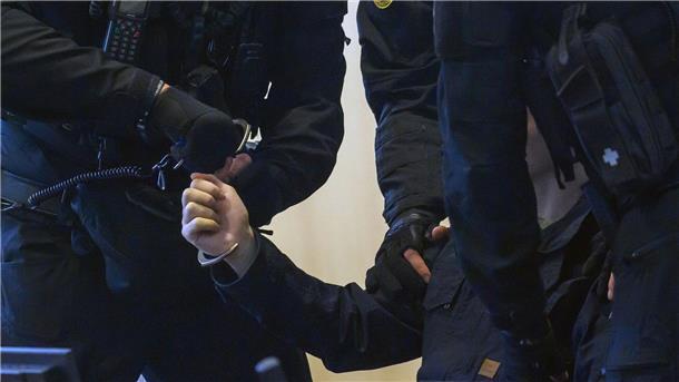 Halle-Attentäter gesteht Geiselnahme in Haft Justizbeamte nehmen dem Angeklagten Stephan Balliet im Gerichtssaal die Handschellen ab.