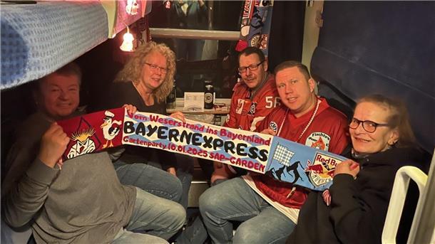 Vom Weserstrand ins Bayernland - Sonderzug nach München Eishockey-Fans halten einen Schal hoch.