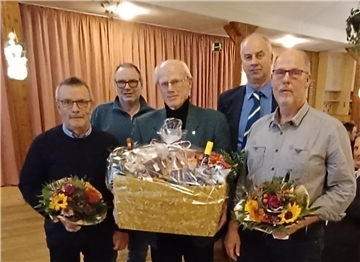 Männer mit Präsentkorb und Blumenstrauß.