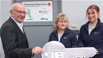 Karl-Heinz Röben, Vorsitzender des DRK-Kreisverbandes Wesermarsch, übergibt Kathleen Hirsch und Chariece Atli als Expertin für die Pflege symbolisch den Schlüssel für die neuen Geschäftsräume des DRK-LifeGRID-Teams in der Breiten Straße 104 in Brake.