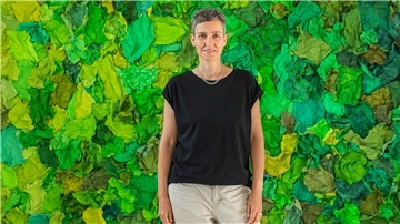 Katja Windau steht vor ihrer raumgreifenden Papierinstallation im Wilke-Atelier, bei der sie ausschließlich mit Grüntönen arbeitet.