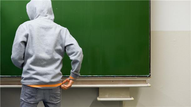 Ein Schüler steht an der Tafel.