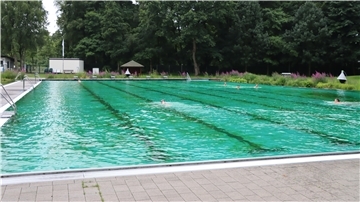 Ein Schwimmbecken mit einigen wenigen Menschen darin.