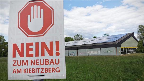 Ärger um Bauprojekte in Nordenham: Politiker will alles auf Eis legen Das Foto zeigt links ein Schild mit der Aufschrift "Nein zum Neubau am Kiebitzberg" und rechts die Tennishalle des SV Nordenham.
