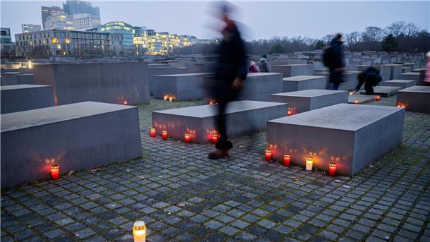Kerzen brennen am Vorabend des Internationalen Tags des Gedenkens an die Opfer des Holocaust zwischen den Stelen des Denkmals für die ermordeten Juden Europas in Berlin.