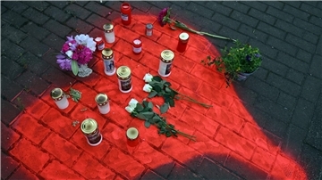 Kerzen und Blumen liegen in einem auf das Pflaster gesprühten roten Herzen in Düsseldorf nach dem mörderischen Brandanschlag.