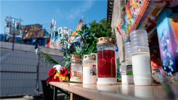 Kerzen und Blumen vor dem Fahrgeschäft „BreakDance“ in Oberhausen, auf dem sich der tödliche Unfall ereignete.