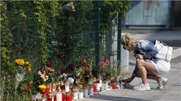 Kerzen und Blumen am Straßenrand. 