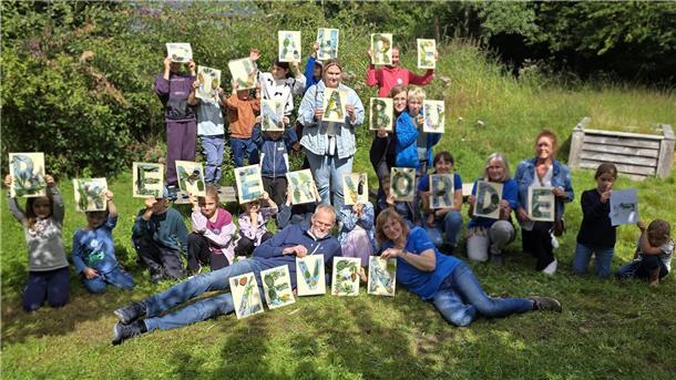 Kinder hatten am Vormittag aus Naturmaterialien des Umweltpyramide-Gartens die 28 Buchstaben „50 Jahre NABU Bremervörde-Zeven“ auf 28 DIN A4-Blätter geklebt. 