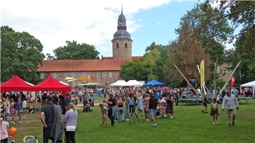Menschen besuchen verschiedene Aktionen in einem Park.