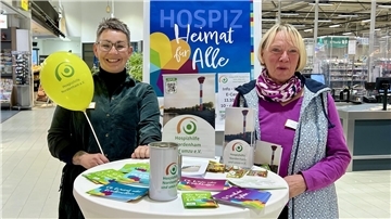 Bild von Kirsten Malle und Karin Miosga von der Hospizhilfe Nordenham an einem Infotisch im E-Center Nordenham