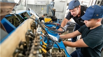 Klaus David (l), Elektriker in Rente, arbeitet mit Johann Müller, Auszubildender zum Mechatroniker.