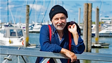 Mann mit Mütze am Hafen