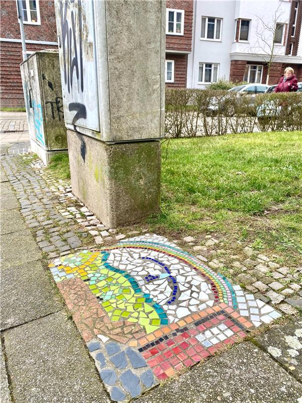 Wie ein bunter Stolperstein die Leichtigkeit des Seins in triste Straßen zaubert Kleines buntes Mosaik zwischen grauen Pflastersteinen mitten in Bremerhaven: Am Waldemar-Becké-Platz hat wohl irgendwer aus den Wohnhäusern ringsum in den Boden ein leuchtendes Regenbogen-Bild gezaubert.