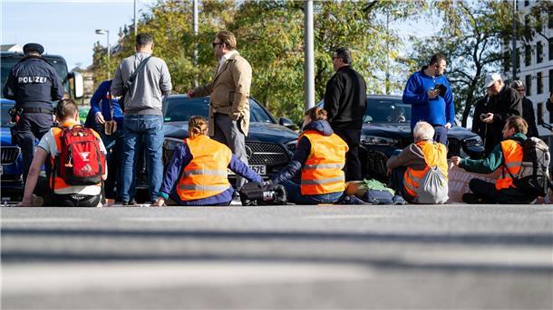 Union fordert härtere Strafen für Klima-Aktivisten Klimaaktivisten haben sich am Karlsplatz in der Münchner Innenstadt auf die Fahrbahn geklebt und blockieren die Straße.
