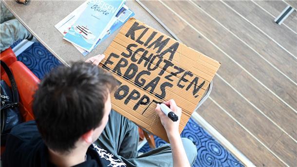 Klimaaktivisten malten erste Protestschilder während der Fährfahrt nach Borkum zum Klimacamp. 