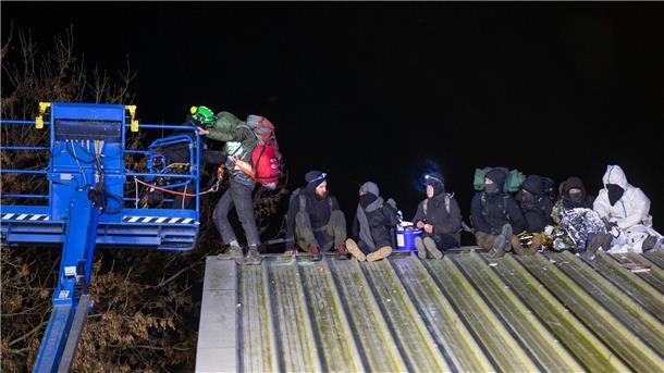 Abrissbagger in Lützerath - Widerstand bröckelt Klimaaktivisten sitzen auf einem Scheunendach und lassen sich von Höhenkletterer der Polizei herunterbringen.