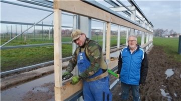 Klootschießer-Kreisvorsitzender Siegfried Hodel (rechts) schaut Benedikt Franz bei den Arbeiten für die Installation von Rollos zu.
