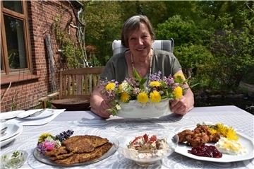 Das Foto zeigt Ursula Schröder mit Löwenzahngerichten. 