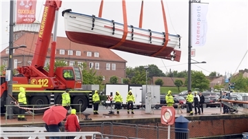Kraneinsatz bei Schietwetter: Das Börteboot der Schiffergilde kommt ins Wasser.