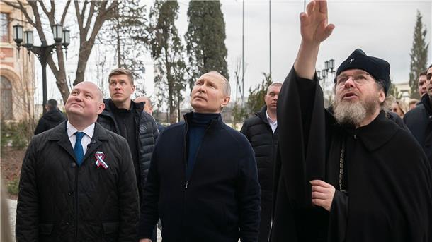 Putin überraschend auf annektierte Halbinsel Krim Kremlchef Putin ist zum neunten Jahrestag der russischen Annexion der Krim zu einem unangekündigten Besuch auf der Schwarzmeer-Halbinsel eingetroffen. Hier zusammen mit dem Gouverneur von Sewastopol, Michail Raswoschajew und Bischof Tichon beim Besuch einer Kunstschule für Kinder.