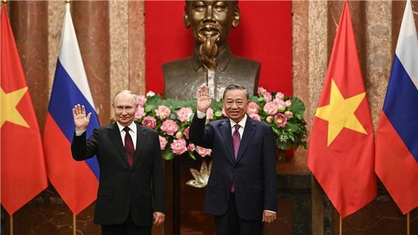 Kremlchef Wladimir Putin (l) und der vietnamesische Präsident To Lam posieren im Präsidentenpalast in Hanoi für die Fotografen.