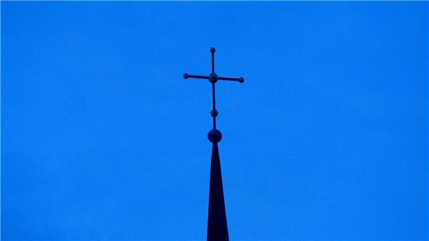 Kreuz einer evangelisch-lutherischen Kirche in der Abenddämmerung.