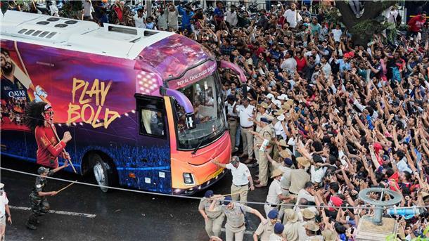 Kricket-Fans in Bengaluru jubeln ihrem Heimteam zu, das in einem Bus sitzt.