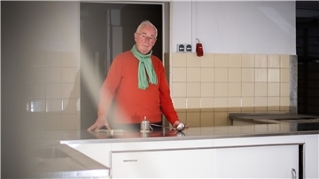 Mann hinter einer Küchenzeile.