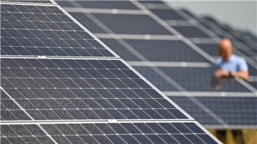 Ein Mann prüft den Zustand von Solarmodulen.