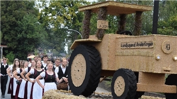 Landjugend Anderlingen in Tracht hinter einem Erntewagen.