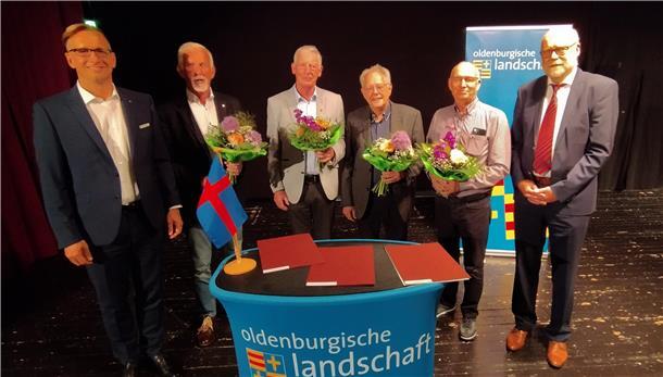 Sechs Männer hinter einem Rednerpult der Oldenburgischen Landschaft