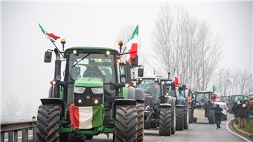 Landwirte fahren mit ihren Traktoren eine Straße an der Mautstelle von Melegnano in der Nähe von Mailand entlang.