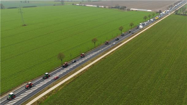 Landwirte fahren mit ihren Traktoren im Schritttempo über eine Bundesstraße.