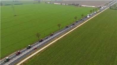 Landwirte fahren mit ihren Traktoren im Schritttempo über eine Bundesstraße.