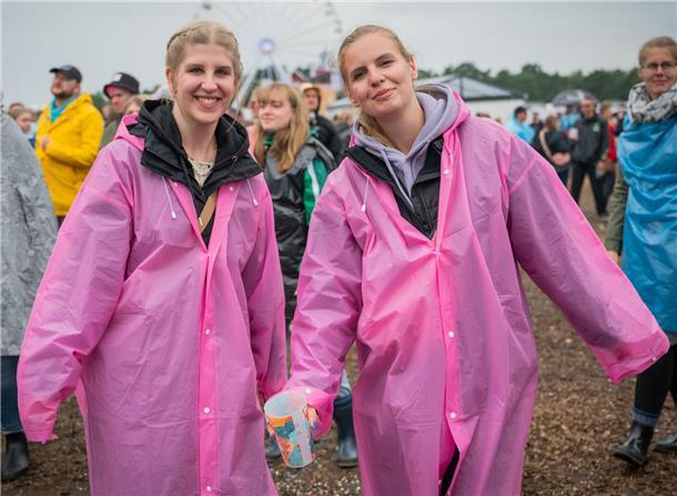 Lara und Annika tragen eine besonders stylishe, pinke Variante der üblichen Regen-Capes.