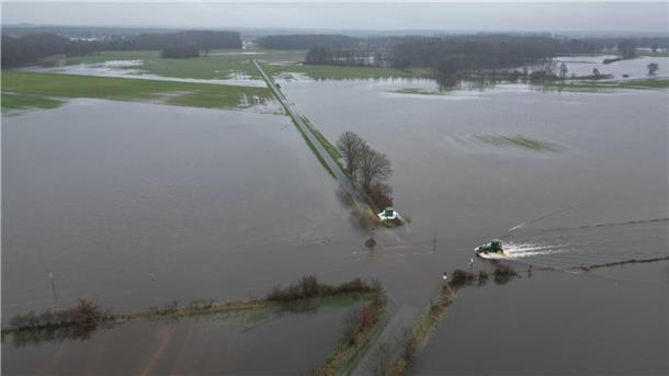 Das Hochwasser von oben: So schlimm ist die Lage im Norden (Bilder) Lathen: Ein Traktor fährt über eine überflutete Straße im Hochwassergebiet.
