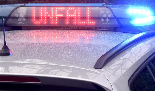 Polizeiauto mit Blaulicht und Schriftzug "Unfall" im Display.