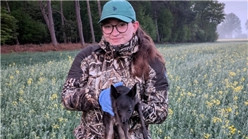 Lea Schlotmann findet ein nicht so häufiges schwarzes Rehkitz auf der Fläche und bringt es gemeinsam mit dem anderen Rehkitz in Sicherheit.