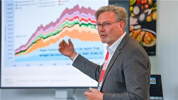 Ein Mann vor einer bunten Grafik.