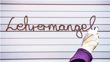An ein Whiteboard wird der Schriftzug "Lehrermangel" geschrieben.
