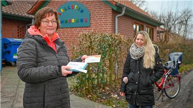 Zwei Frauen stehen vor einer Kindertagesstätte, in der Hand hält eine von ihnen einen Corona-Schnelltest.