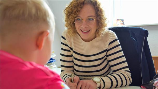 Die Logopädin Lena Wragge sitzt einem Jungen gegenüber, der in seiner Sprachentwicklung gefördert wird. 